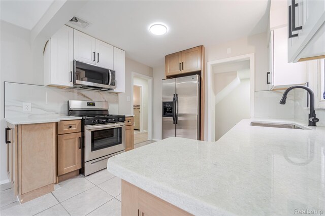 15648 Stricker Ave, Sterling Heights, MI 48021 - kitchen featuring appliances with stainless steel finishes, light stone countertops, light tile patterned floors, tasteful backsplash, and a peninsula