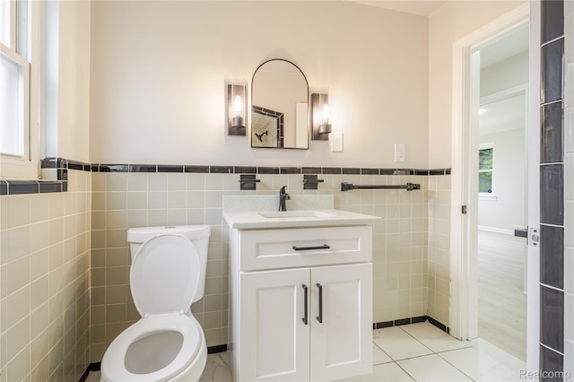 15648 Stricker Ave, Sterling Heights, MI 48021 - half bathroom with tile walls, vanity, a wainscoted wall, and tile patterned flooring
