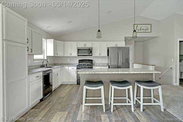 453 Angle Rd, Lapeer, MI 48446 - kitchen featuring appliances with stainless steel finishes, lofted ceiling, wood finished floors, white cabinetry, and a kitchen island