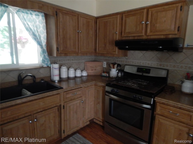 15274 Regina Ave, Allen Park, MI 48101 - kitchen featuring stainless steel range with gas stovetop, exhaust hood, tasteful backsplash, dark wood-type flooring, and brown cabinetry