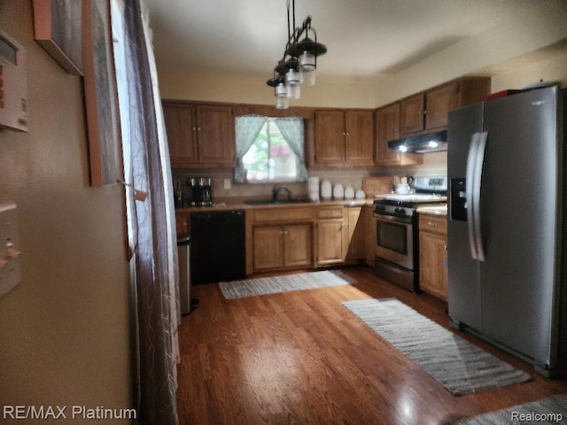 15274 Regina Ave, Allen Park, MI 48101 - kitchen with stainless steel appliances, under cabinet range hood, brown cabinetry, and light countertops