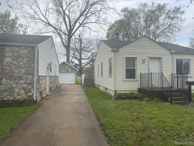 248 W Longfellow Ave, Pontiac, MI 48340 - view of front of house featuring a garage, an outdoor structure, a front lawn, and a shingled roof
