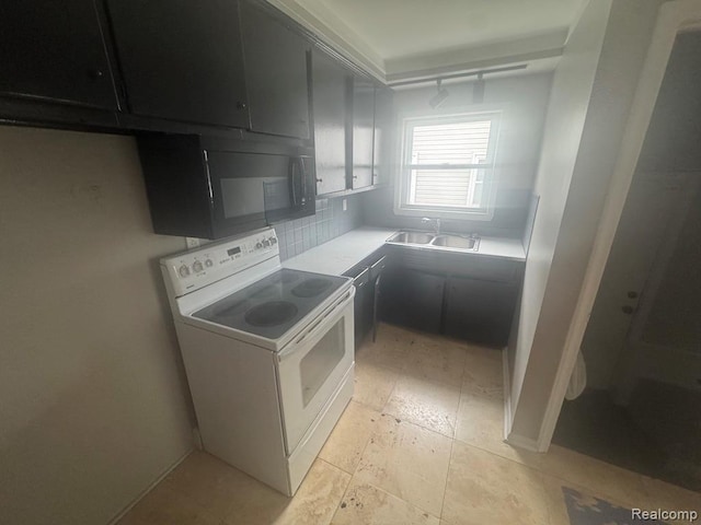 248 W Longfellow Ave, Pontiac, MI 48340 - kitchen featuring black microwave, white range with electric stovetop, light countertops, dark cabinets, and decorative backsplash