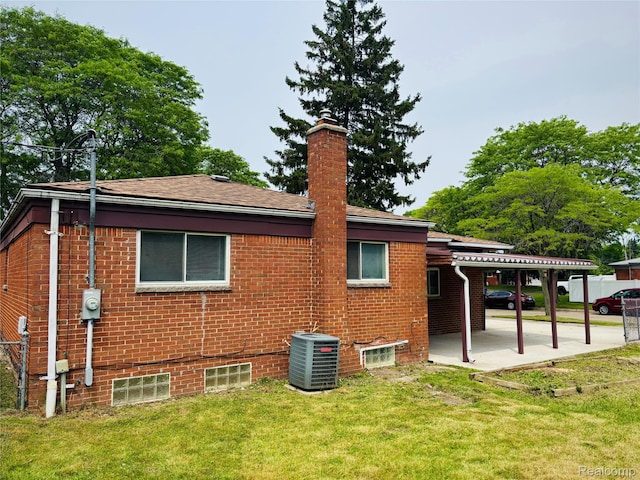 26046 Eureka Dr, Warren, MI 48091 - back of house with a patio, a lawn, brick siding, and a chimney