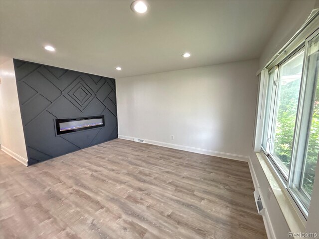 26046 Eureka Dr, Warren, MI 48091 - unfurnished living room featuring a fireplace, recessed lighting, and wood finished floors