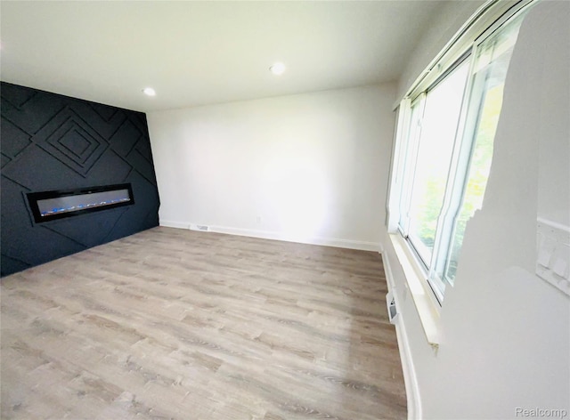 26046 Eureka Dr, Warren, MI 48091 - unfurnished living room featuring a large fireplace, wood finished floors, and recessed lighting