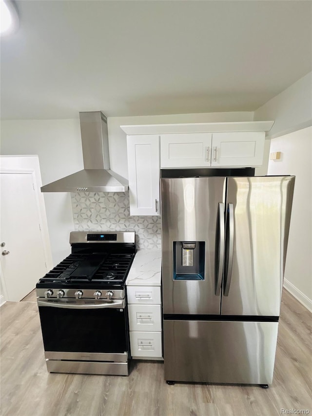 26046 Eureka Dr, Warren, MI 48091 - kitchen with appliances with stainless steel finishes, wall chimney range hood, light wood finished floors, white cabinets, and tasteful backsplash