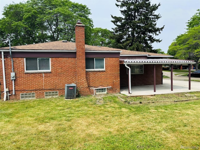 26046 Eureka Dr, Warren, MI 48091 - rear view of property with a yard, a chimney, a patio, and brick siding
