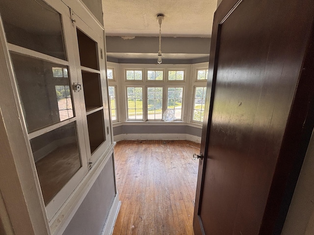 1407 Michigan Ave, Alma, MI 48801 - corridor with hardwood / wood-style floors and a textured ceiling
