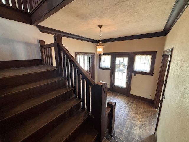 1407 Michigan Ave, Alma, MI 48801 - foyer entrance with a textured ceiling, dark wood finished floors, plenty of natural light, stairway, and ornamental molding