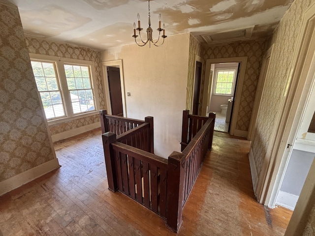 1407 Michigan Ave, Alma, MI 48801 - hall featuring an upstairs landing, wallpapered walls, hardwood / wood-style floors, and a chandelier
