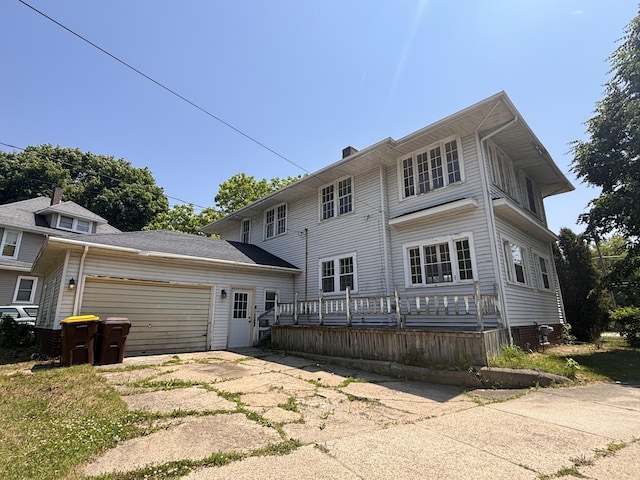 1407 Michigan Ave, Alma, MI 48801 - rear view of house with an attached garage, concrete driveway, and a chimney