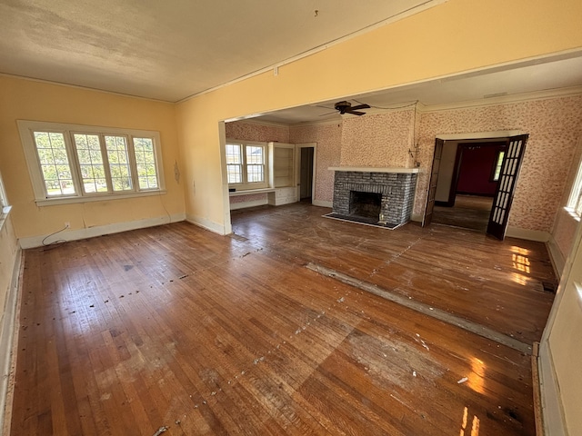 1407 Michigan Ave, Alma, MI 48801 - unfurnished living room featuring a brick fireplace, wood-type flooring, and ceiling fan
