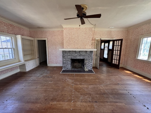 1407 Michigan Ave, Alma, MI 48801 - unfurnished living room with wallpapered walls, dark wood-style floors, crown molding, a ceiling fan, and a brick fireplace