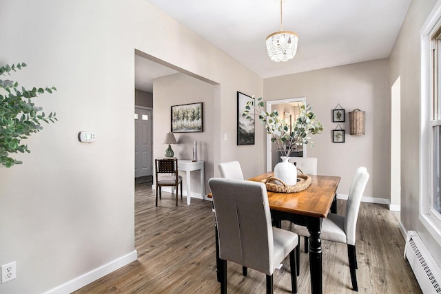 140 W Corey St, Bronson, MI 49028 - dining room featuring baseboard heating, a chandelier, and wood finished floors