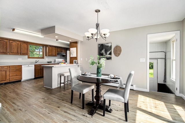 140 W Corey St, Bronson, MI 49028 - dining area featuring wood finished floors, a chandelier, a baseboard radiator, and recessed lighting