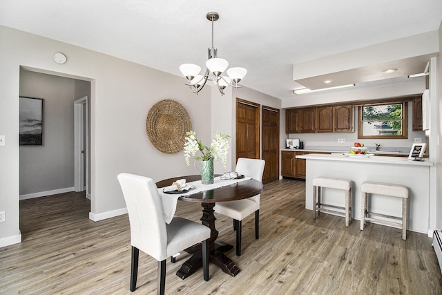 140 W Corey St, Bronson, MI 49028 - dining room featuring a chandelier, light wood-type flooring, and a baseboard radiator