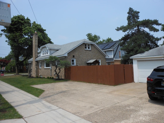 2356 SE Paris, Grand Rapids, MI 49507 - view of front of home with driveway, a garage, brick siding, and a chimney