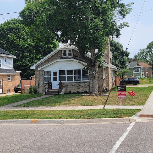 2356 SE Paris, Grand Rapids, MI 49507 - bungalow featuring stone siding, a front yard, and entry steps