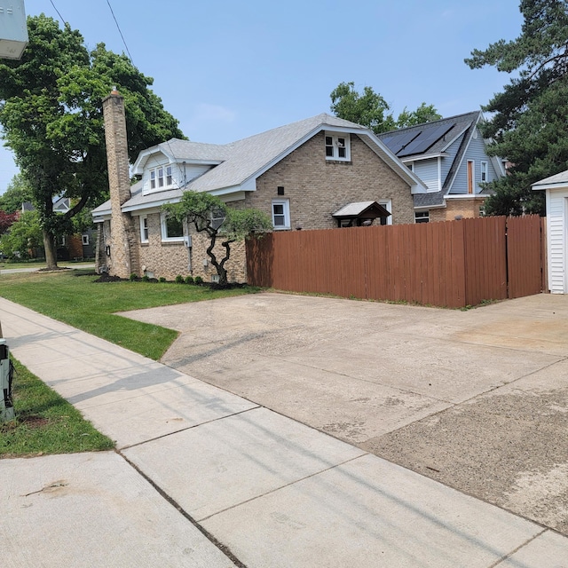 2356 SE Paris, Grand Rapids, MI 49507 - view of side of home with brick siding, a chimney, and driveway