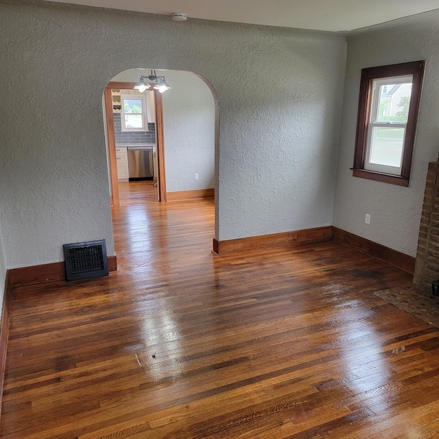 2356 SE Paris, Grand Rapids, MI 49507 - unfurnished room with a textured wall, arched walkways, wood-type flooring, a smoke detector, and healthy amount of natural light