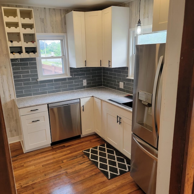 2356 SE Paris, Grand Rapids, MI 49507 - kitchen with stainless steel appliances, tasteful backsplash, wood finished floors, and white cabinetry