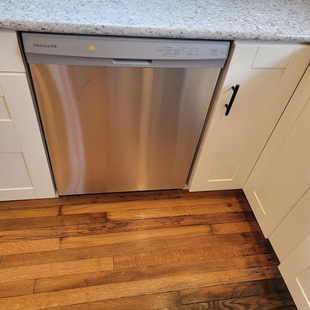 2356 SE Paris, Grand Rapids, MI 49507 - kitchen view of stainless steel dishwasher, white cabinets, and wood finished floors