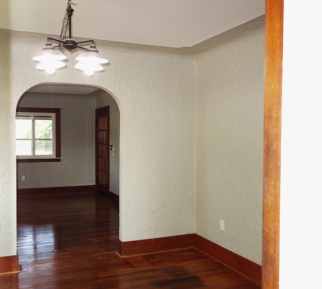 2356 SE Paris, Grand Rapids, MI 49507 - spare room with arched walkways, wood finished floors, a chandelier, and a textured wall