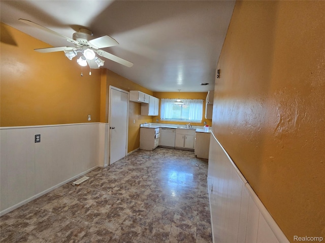 21450 Evergreen Rd, Southfield, MI 48075 - kitchen with white dishwasher, ceiling fan, white cabinetry, and light countertops