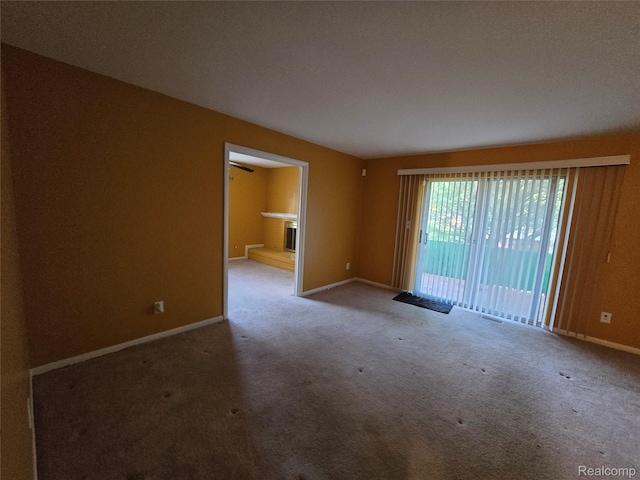 21450 Evergreen Rd, Southfield, MI 48075 - spare room featuring carpet and a fireplace with raised hearth