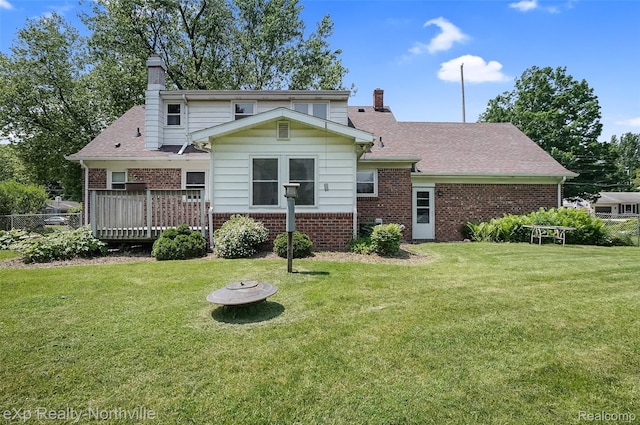 517 S Scott St, Adrian, MI 49221 - back of house featuring brick siding, a chimney, and a yard