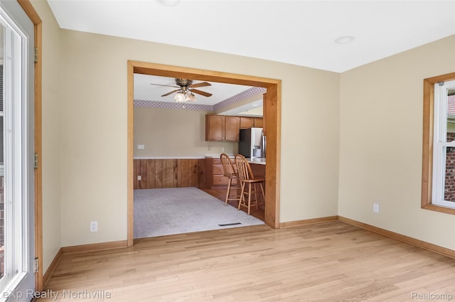 517 S Scott St, Adrian, MI 49221 - unfurnished living room with a ceiling fan, light wood-style flooring, and wainscoting