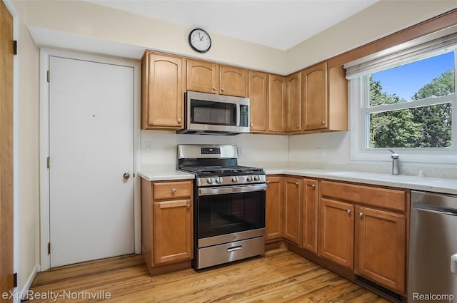 517 S Scott St, Adrian, MI 49221 - kitchen featuring stainless steel appliances, light countertops, light wood finished floors, and brown cabinets