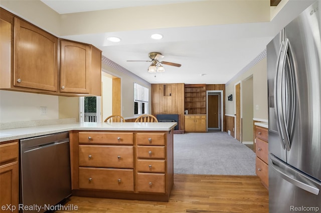 517 S Scott St, Adrian, MI 49221 - kitchen featuring appliances with stainless steel finishes, a peninsula, a ceiling fan, light countertops, and brown cabinets