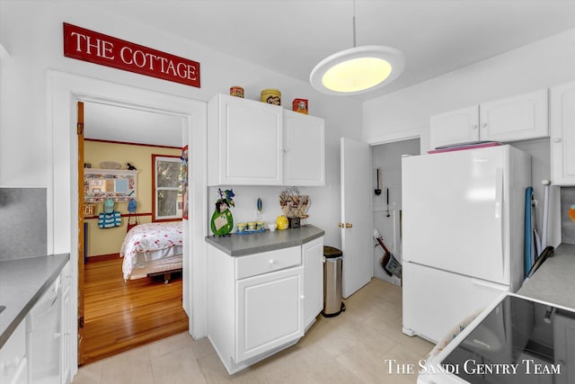 508 Fulton St, Grand Haven, MI 49417 - kitchen featuring freestanding refrigerator, white cabinetry, and pendant lighting