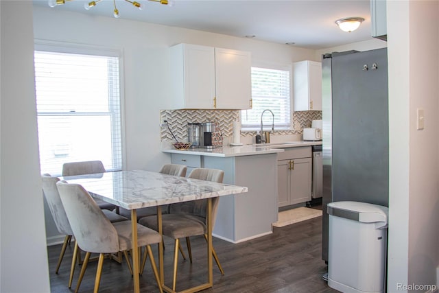 21110 Van Buren St, Southfield, MI 48033 - kitchen with tasteful backsplash, dark wood-style floors, light countertops, white cabinets, and appliances with stainless steel finishes