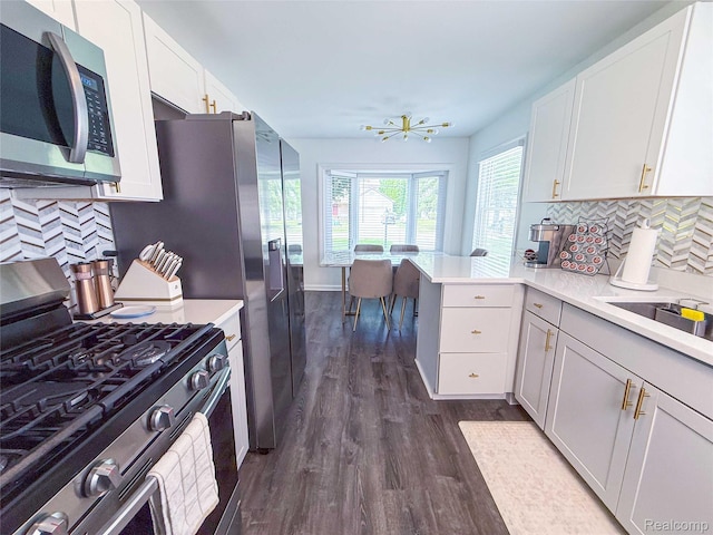 21110 Van Buren St, Southfield, MI 48033 - kitchen with appliances with stainless steel finishes, dark wood-style floors, light countertops, white cabinetry, and a peninsula