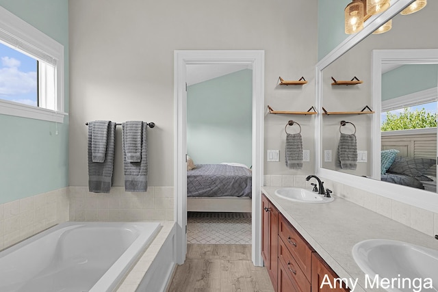 1824 Restoration Dr SW, Byron Center, MI 49315 - bathroom featuring ensuite bathroom, double vanity, a garden tub, and wood finished floors