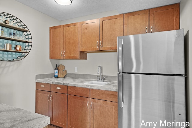 1824 Restoration Dr SW, Byron Center, MI 49315 - kitchen with freestanding refrigerator, light countertops, brown cabinets, and a textured ceiling