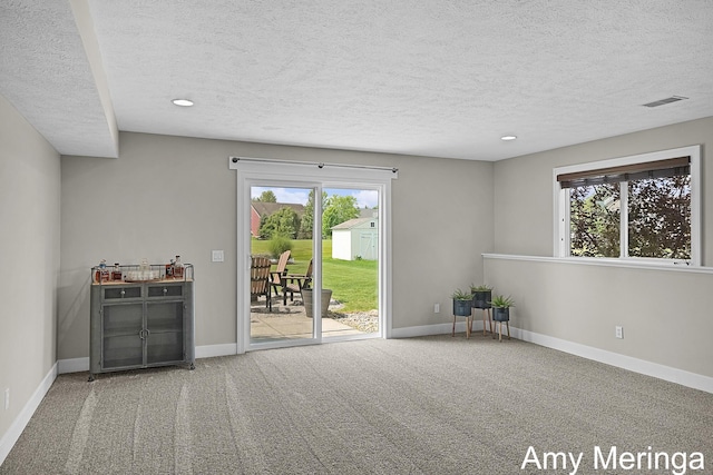 1824 Restoration Dr SW, Byron Center, MI 49315 - unfurnished living room featuring a textured ceiling, carpet floors, and recessed lighting