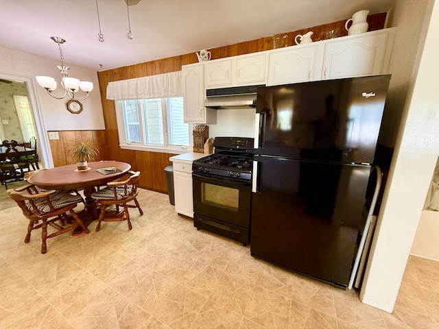 16130 Addison Rd, Addison, MI 49220 - kitchen with black appliances, under cabinet range hood, white cabinets, a chandelier, and hanging light fixtures