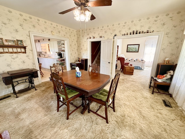 16130 Addison Rd, Addison, MI 49220 - dining room with wallpapered walls, light colored carpet, a ceiling fan, and stairway