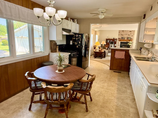 16130 Addison Rd, Addison, MI 49220 - dining space with a ceiling fan, a chandelier, and a fireplace