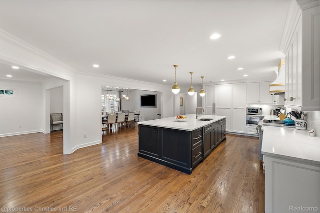 1174 Lakeside Dr, Birmingham, MI 48009 - kitchen with white cabinetry, light countertops, ornamental molding, recessed lighting, and an island with sink