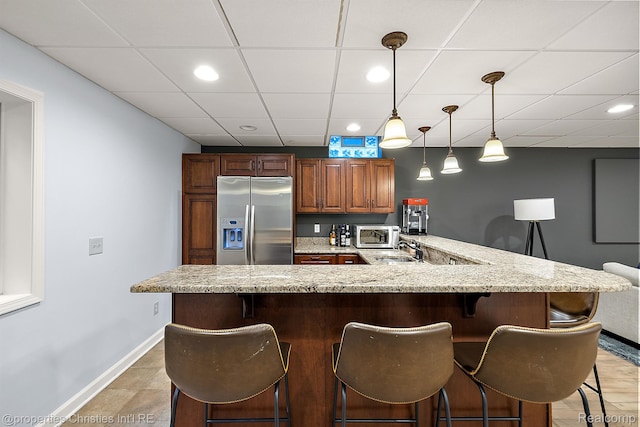 1174 Lakeside Dr, Birmingham, MI 48009 - kitchen with appliances with stainless steel finishes, a kitchen breakfast bar, a drop ceiling, light stone countertops, and pendant lighting