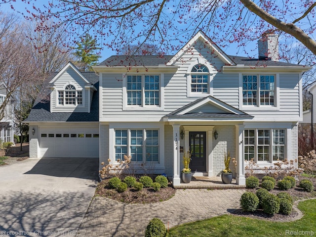 1174 Lakeside Dr, Birmingham, MI 48009 - traditional-style home with concrete driveway, a chimney, brick siding, and roof with shingles
