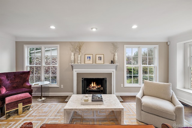 1174 Lakeside Dr, Birmingham, MI 48009 - living area featuring plenty of natural light, wood finished floors, a warm lit fireplace, and recessed lighting