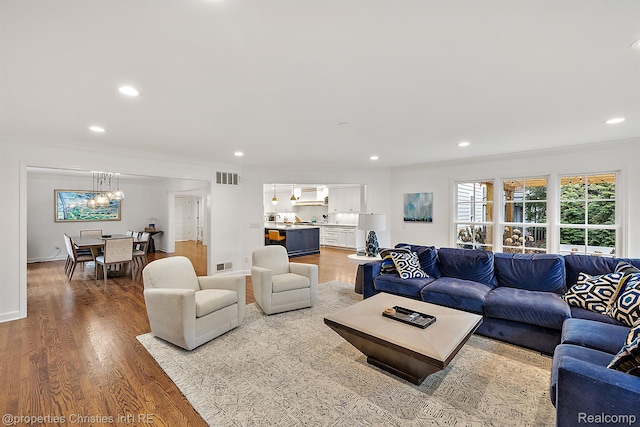 1174 Lakeside Dr, Birmingham, MI 48009 - living room featuring a chandelier, crown molding, wood finished floors, and recessed lighting