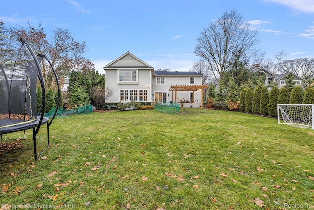 1174 Lakeside Dr, Birmingham, MI 48009 - back of property with a trampoline, a pergola, and a lawn