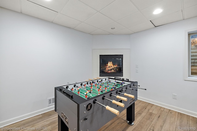 1174 Lakeside Dr, Birmingham, MI 48009 - playroom featuring light wood-type flooring, a drop ceiling, a glass covered fireplace, and recessed lighting